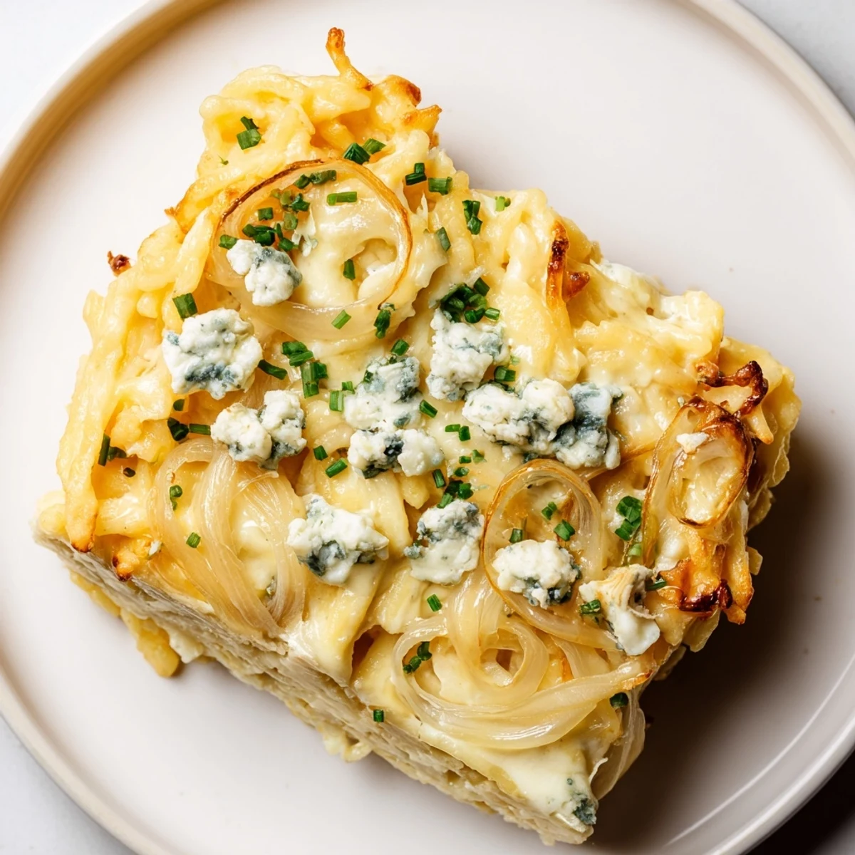 Close-up of bubbling Käse-Spätzle Luxus with melted Gorgonzola, ready for serving with chives.