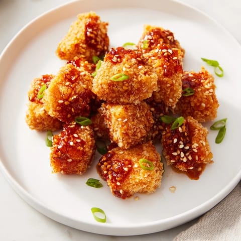 Close-up of golden brown Honey-Sriracha Chicken Bites, perfect for game day or a flavorful snack.