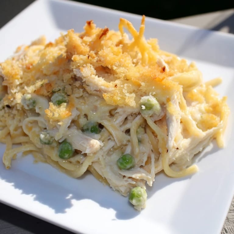 Hot, creamy Turkey/Chicken Tetrazzini bake, featuring shredded chicken, peas, and melted cheese, so delicious!